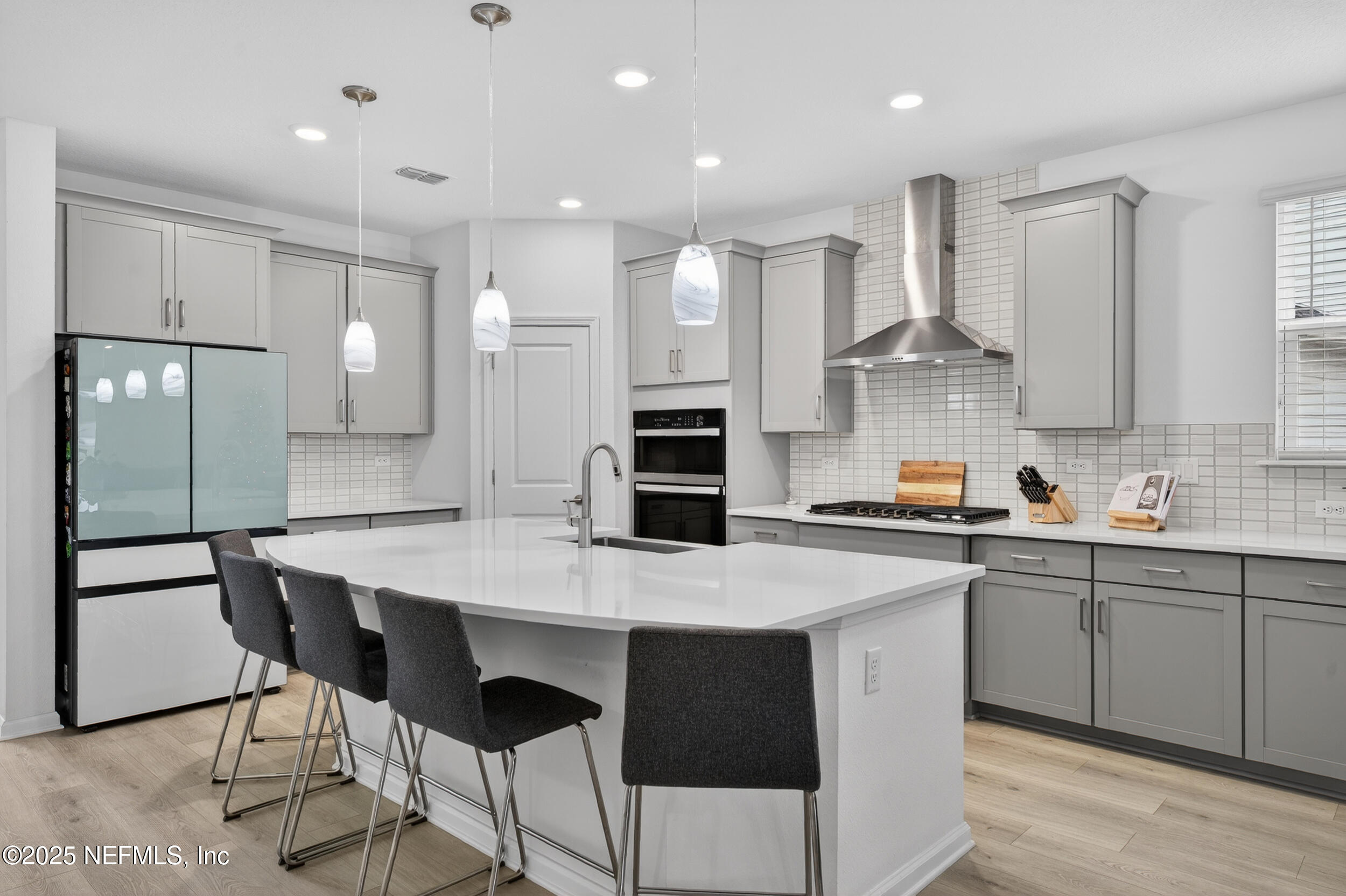 267 Twilight Lane St. Augustine, FL 32095 - Photo 7 of 50 a kitchen with stainless steel appliances kitchen island granite countertop a sink a stove a refrigerator and island with wooden floor