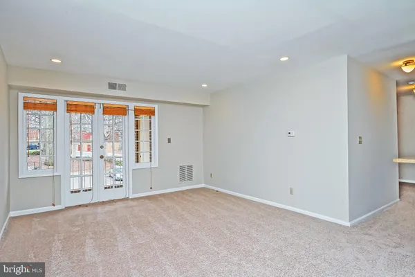 an empty room with windows and view of an empty room