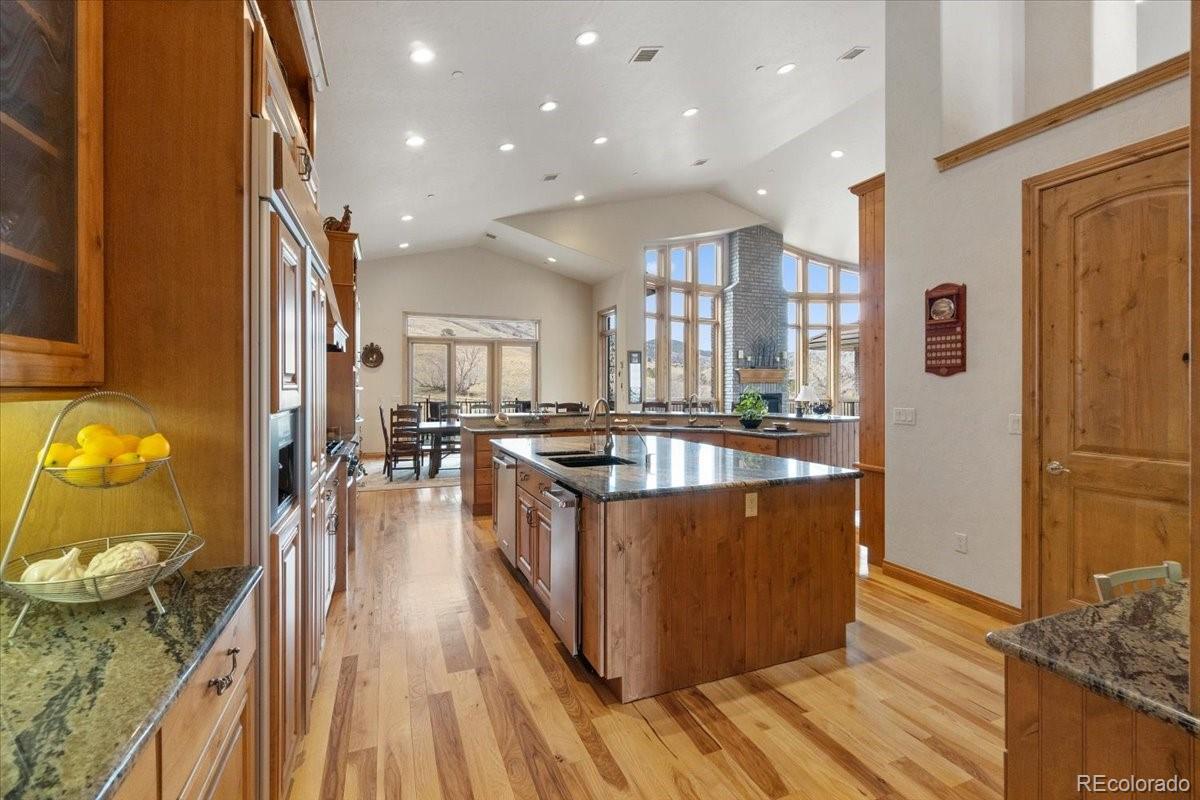 5881 Deer Meadow Trail Golden, CO 80403 - Photo 19 of 50 a large kitchen with stainless steel appliances granite countertop a large counter top a stove and a wooden floors