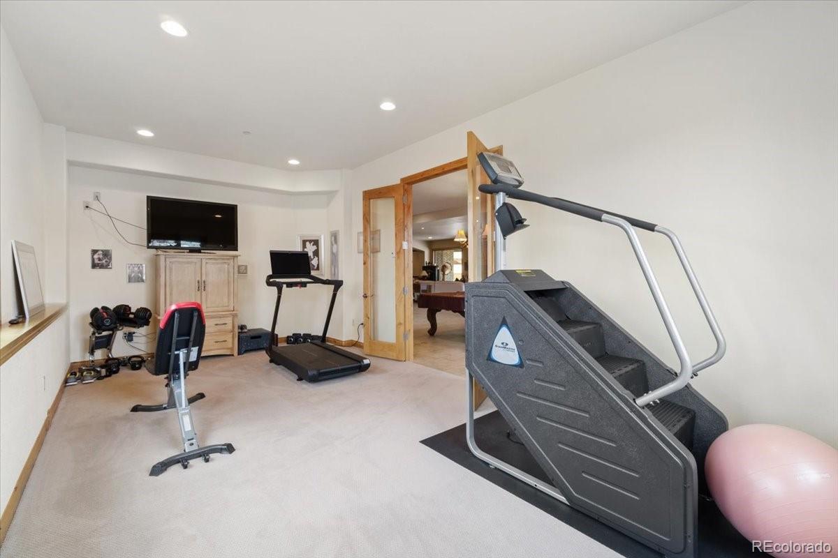 5881 Deer Meadow Trail Golden, CO 80403 - Photo 32 of 50 a room with gym equipment and a flat screen tv