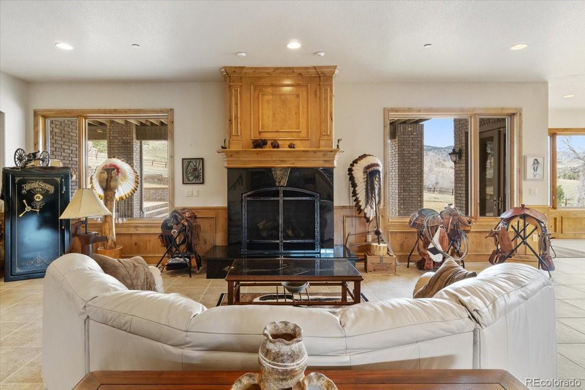 5881 Deer Meadow Trail Golden, CO 80403 - Photo 37 of 50 a living room with furniture a fireplace and a flat screen tv