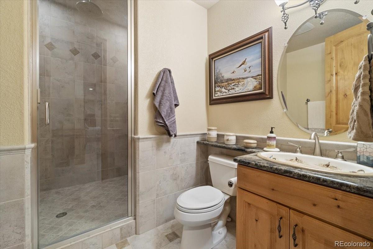 5881 Deer Meadow Trail Golden, CO 80403 - Photo 40 of 50 a bathroom with a granite countertop toilet sink and mirror