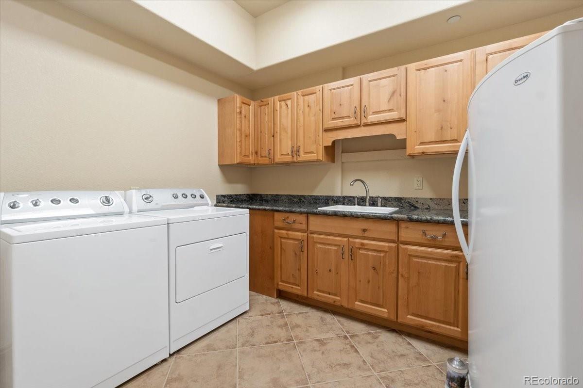 5881 Deer Meadow Trail Golden, CO 80403 - Photo 44 of 50 a kitchen with granite countertop cabinets sink and white appliances