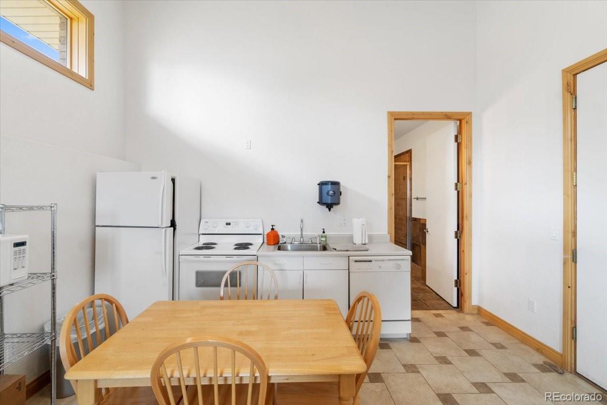 5881 Deer Meadow Trail Golden, CO 80403 - Photo 47 of 50 a kitchen with a table chairs refrigerator and stove