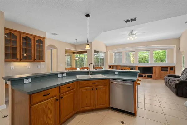 a kitchen with refrigerator a stove a sink and a dining table with wooden floor