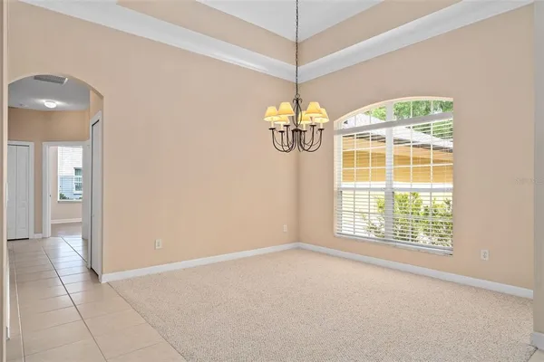 an empty room with wooden floor ceiling fan and window