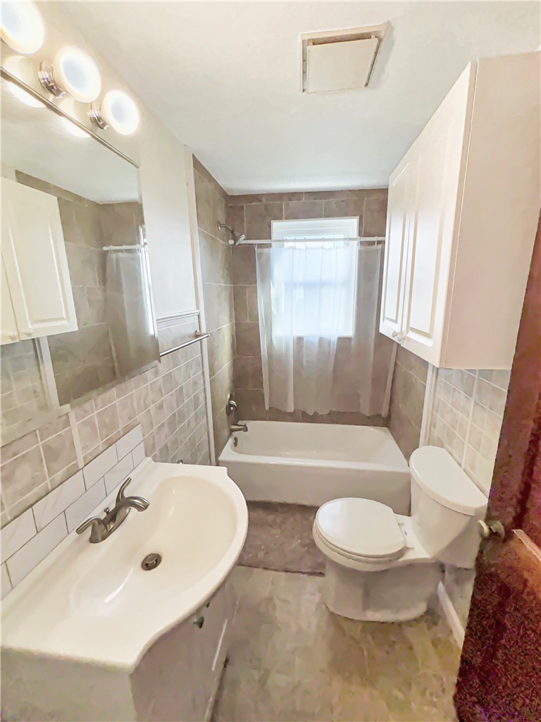 8411 Pitsburg-Laura Road Arcanum, OH 45304 - Photo 11 of 16 This functional bathroom features practical fixtures and neutral tilework, creating a clean and accessible space.