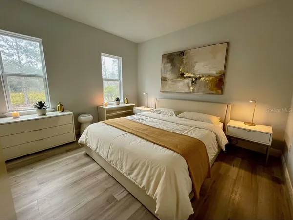 a bedroom with a bed and wooden floor