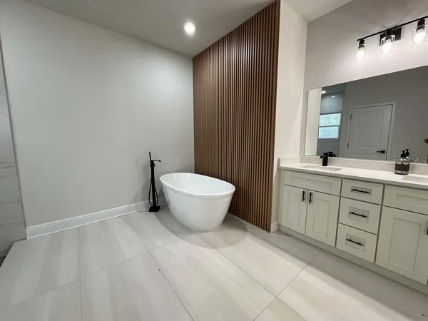 a bedroom with bed and wooden floor