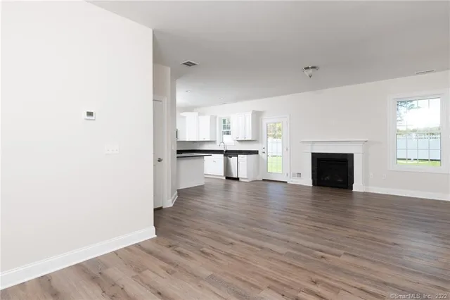 a view of a kitchen with wooden floor and a fireplace