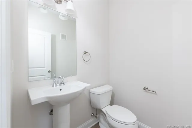 a bathroom with a sink a toilet and mirror