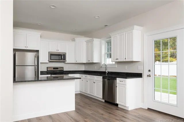 a kitchen with stainless steel appliances granite countertop a stove a sink and a microwave
