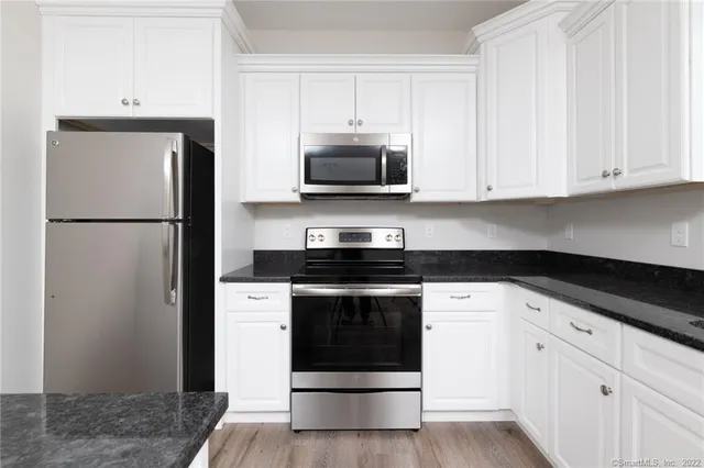 a kitchen with white cabinets and stainless steel appliances