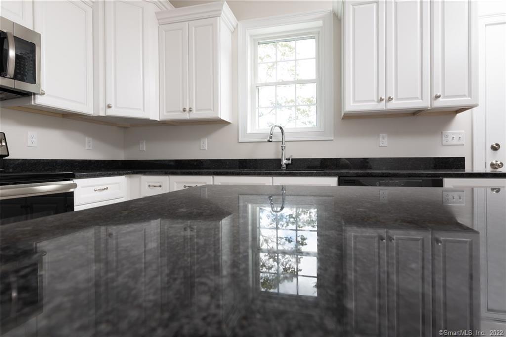 29 Covey Road, Unit 13 Burlington, CT 06013 - Photo 6 of 34 a kitchen with granite countertop white cabinets and a sink