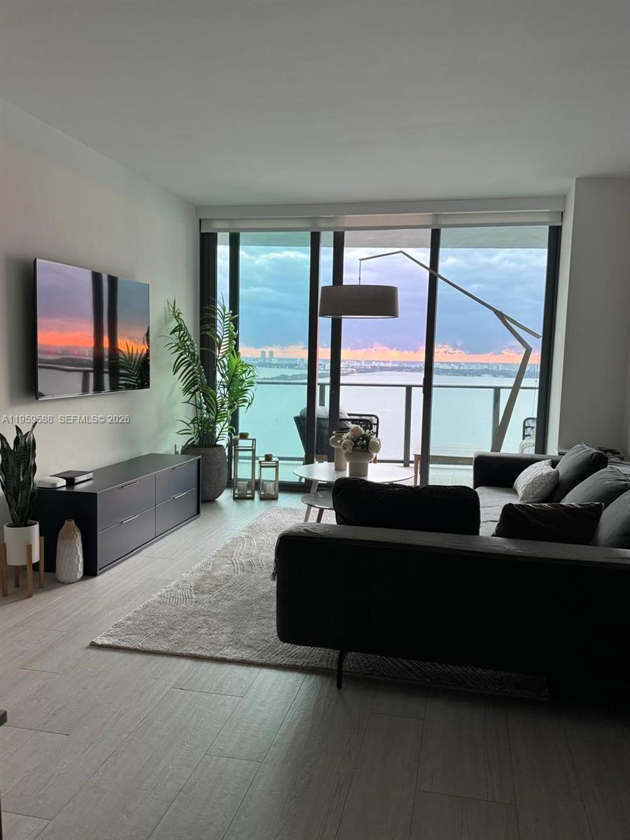 460 Northeast 28th Street, Unit 3307 Miami, FL 33137 - Photo 4 of 13 a living room with furniture a large window and flat screen tv
