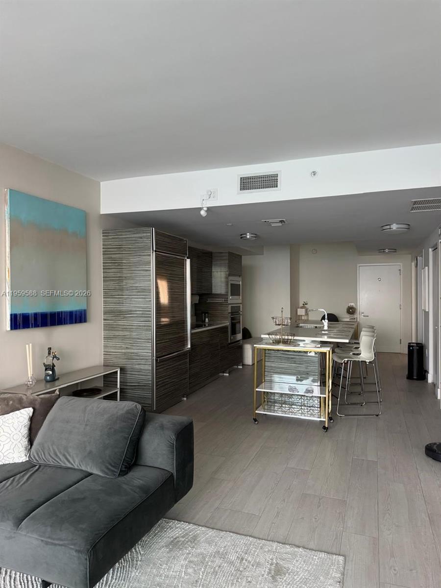 460 Northeast 28th Street, Unit 3307 Miami, FL 33137 - Photo 5 of 13 a living room with furniture and a flat screen tv