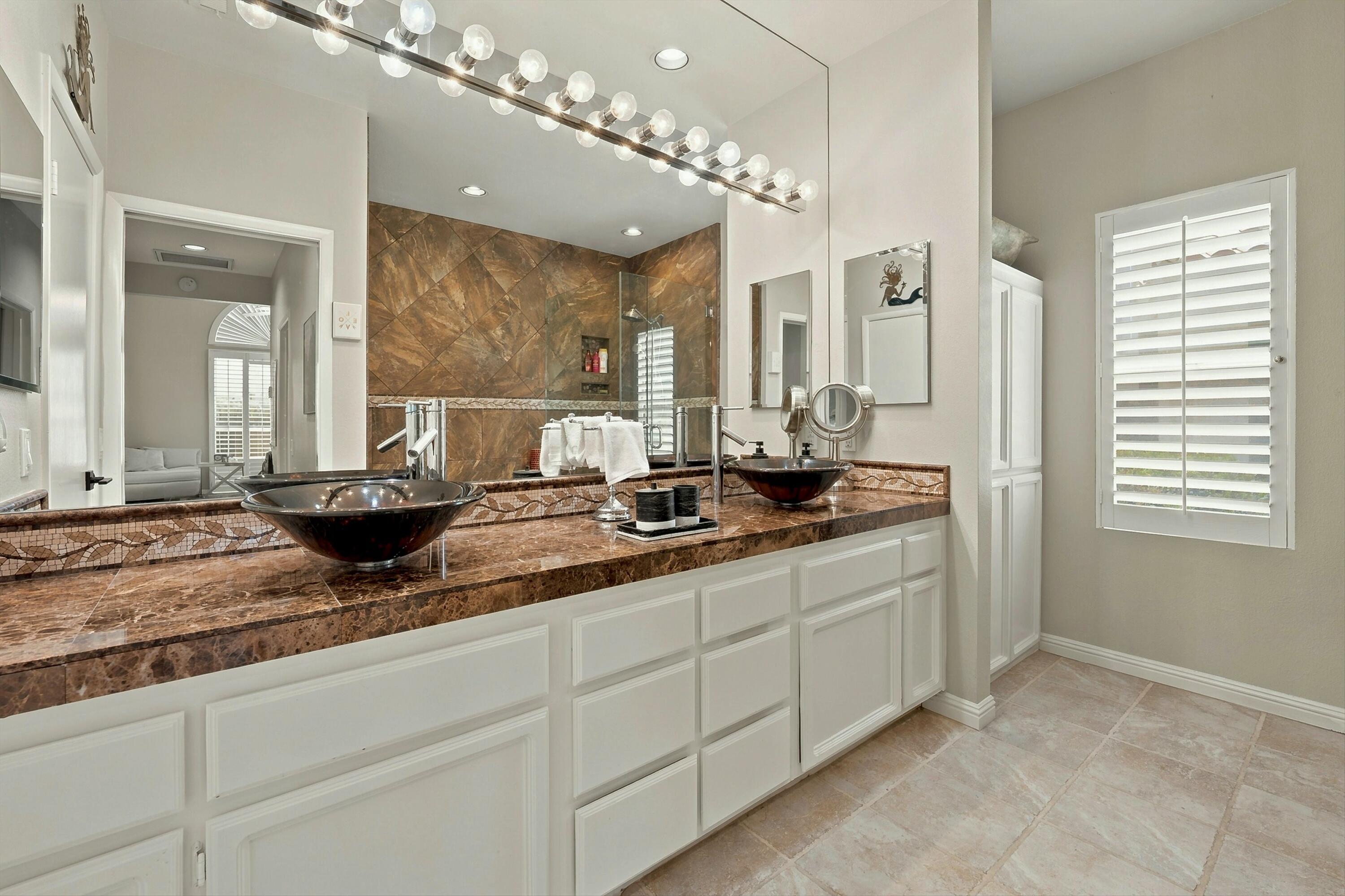 138 Lakeshore Drive Rancho Mirage, CA 92270 - Photo 17 of 30 a bathroom with double vanity sinks a large mirror and a shower