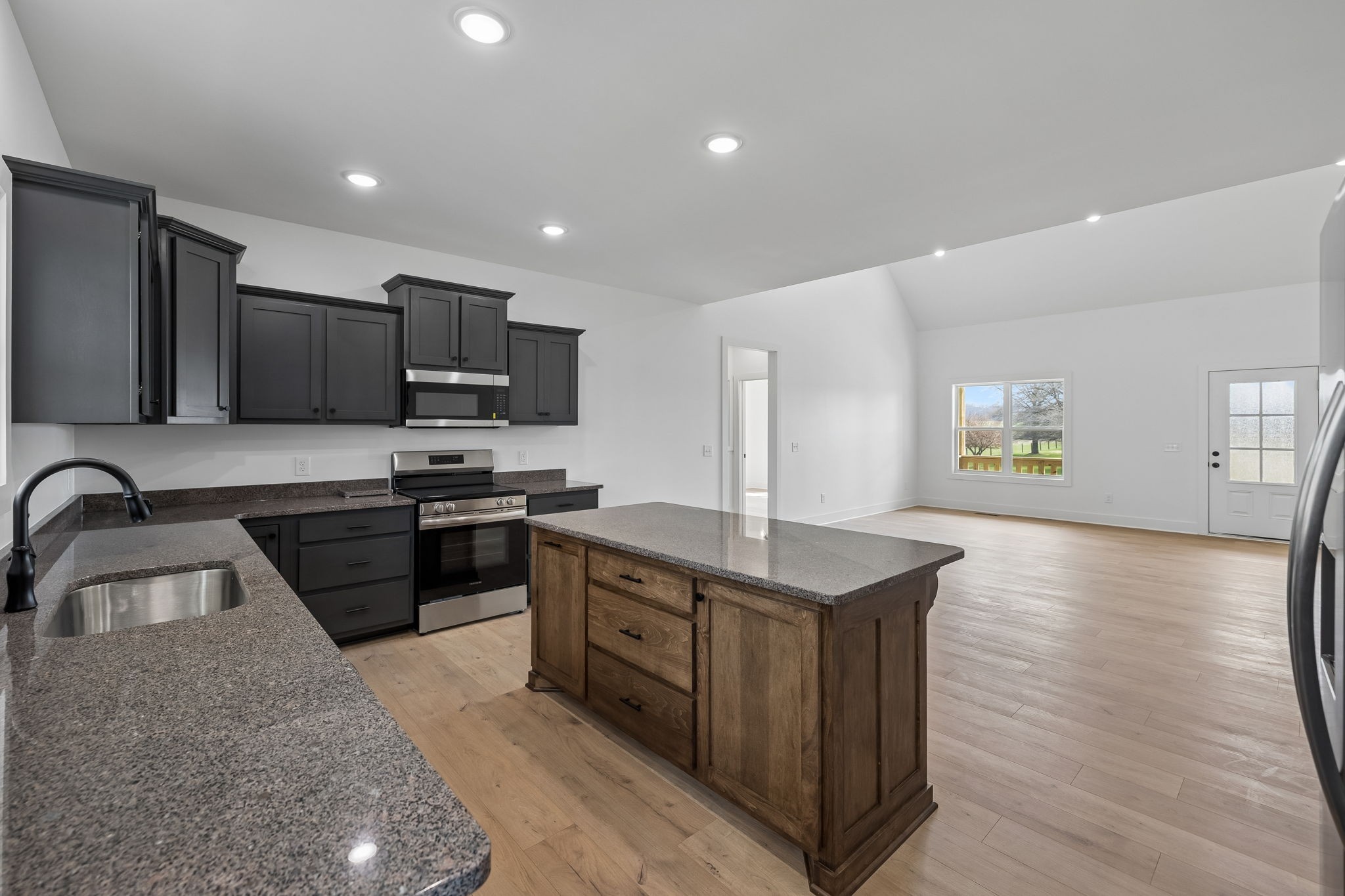 4083 Long Creek Road Lafayette, TN 37083 - Photo 13 of 36 a kitchen with stainless steel appliances granite countertop a sink dishwasher stove and oven with wooden floor