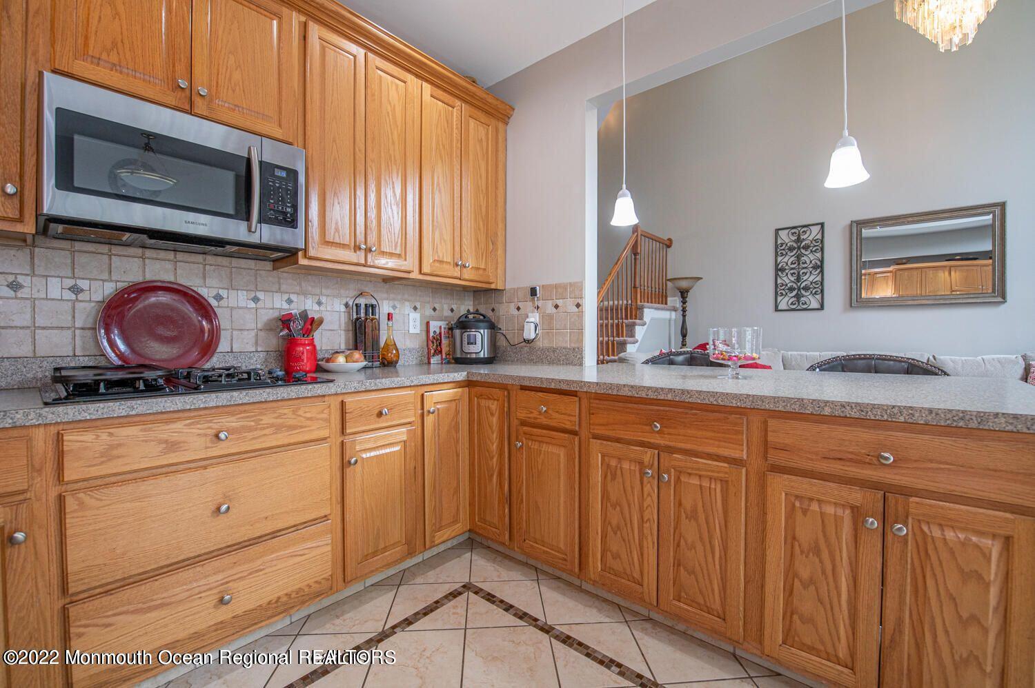 109 Brookfield Drive Jackson, NJ 08527 - Photo 18 of 40 a kitchen with stainless steel appliances granite countertop a sink dishwasher stove and oven with wooden cabinets