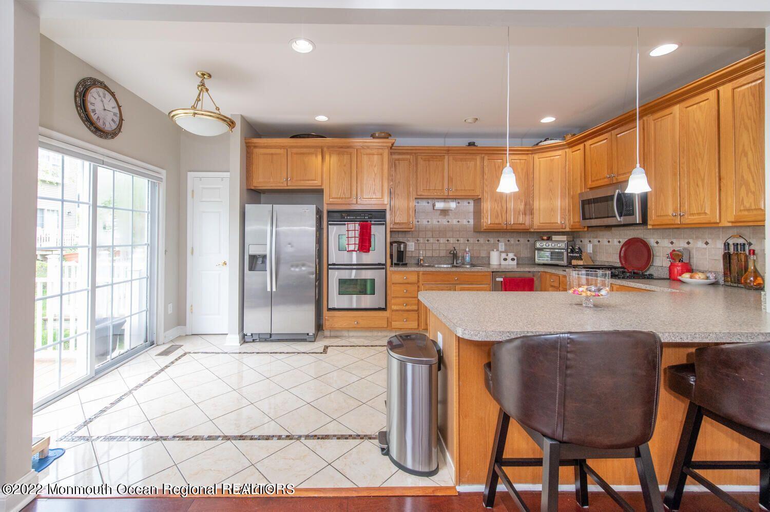 109 Brookfield Drive Jackson, NJ 08527 - Photo 20 of 40 a kitchen with stainless steel appliances kitchen island granite countertop a refrigerator a stove and a wooden cabinets with wooden floor