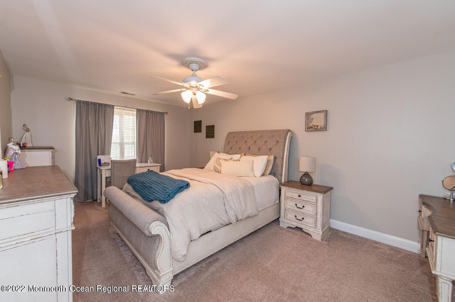 109 Brookfield Drive Jackson, NJ 08527 - Photo 24 of 40 a bedroom with a bed and a chandelier