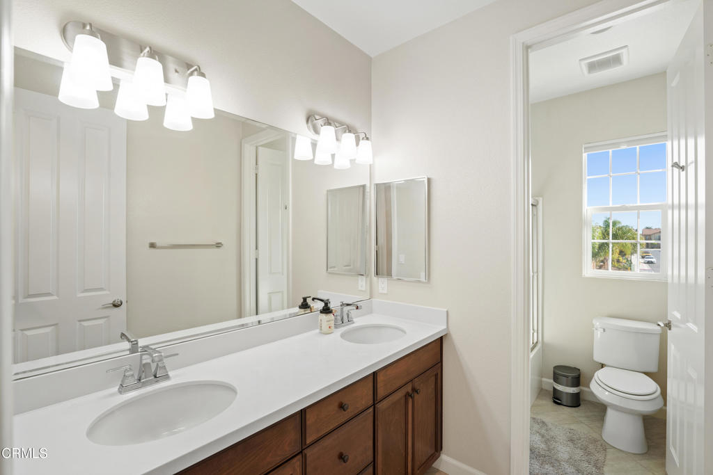 1655 Range Road Oxnard, CA 93036 - Photo 21 of 34 a bathroom with a toilet a sink a light fixture and a mirror