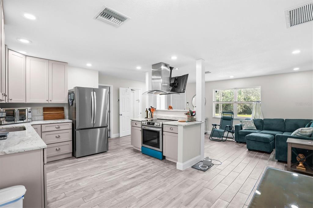 6244 Colony Circle Weeki Wachee, FL 34607 - Photo 40 of 60 a kitchen with stainless steel appliances kitchen island granite countertop a refrigerator stove and sink