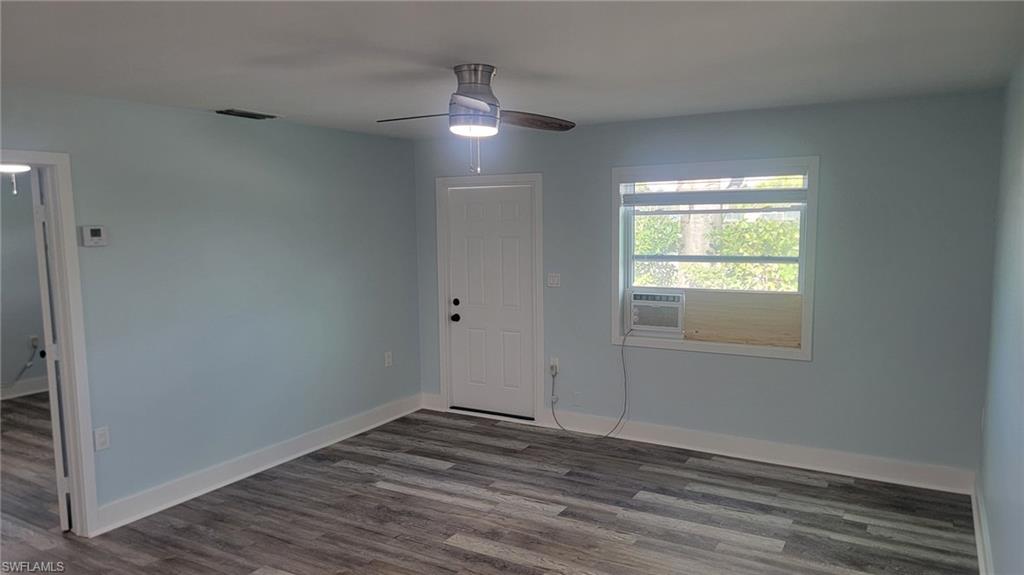 27020 Williams Road, Unit 5 Bonita Springs, FL 34135 - Photo 3 of 6 an empty room with wooden floor and windows