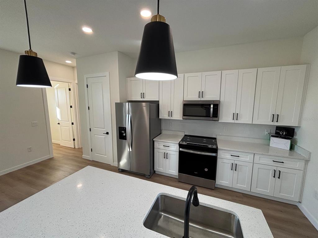 15215 Southwest 43rd Court Ocala, FL 34473 - Photo 11 of 29 a kitchen with a sink a refrigerator and a stove