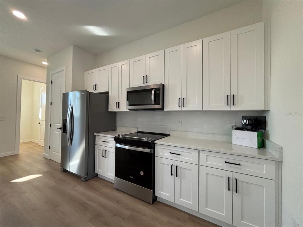 15215 Southwest 43rd Court Ocala, FL 34473 - Photo 12 of 29 a kitchen with white cabinets and stainless steel appliances