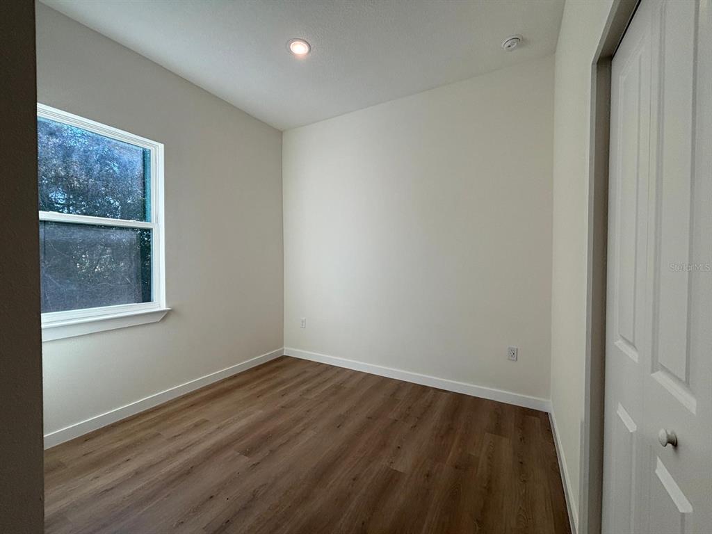 15215 Southwest 43rd Court Ocala, FL 34473 - Photo 15 of 29 a view of an empty room with wooden floor and a window