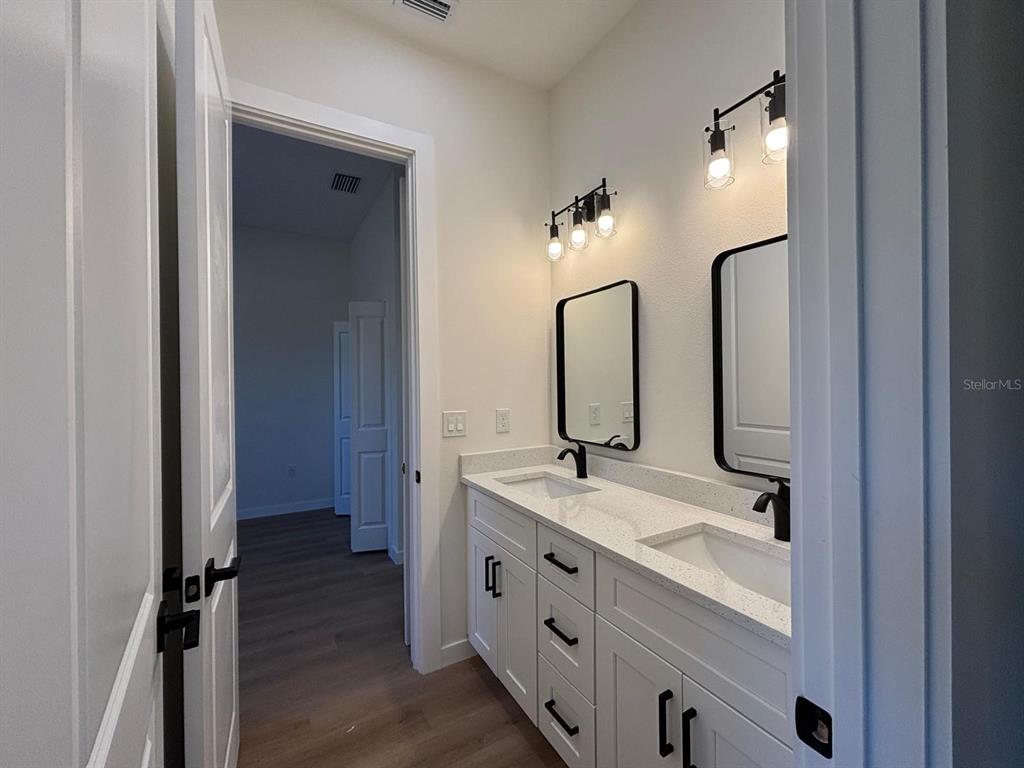 15215 Southwest 43rd Court Ocala, FL 34473 - Photo 19 of 29 a bathroom with a double vanity sink and mirror