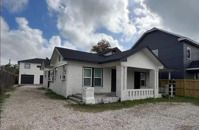 a view of a house with a yard and fence