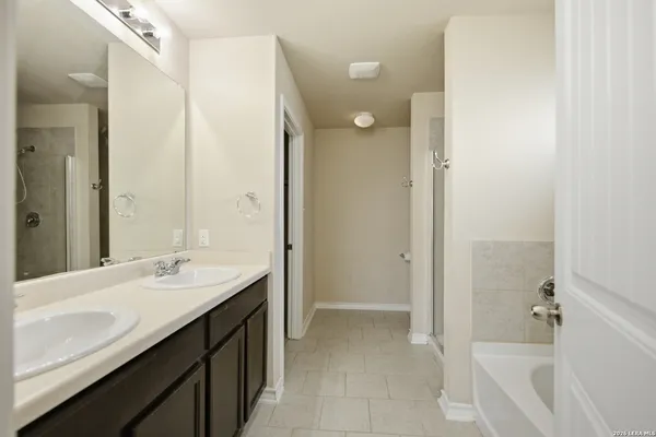 a bathroom with a tub sink and mirror