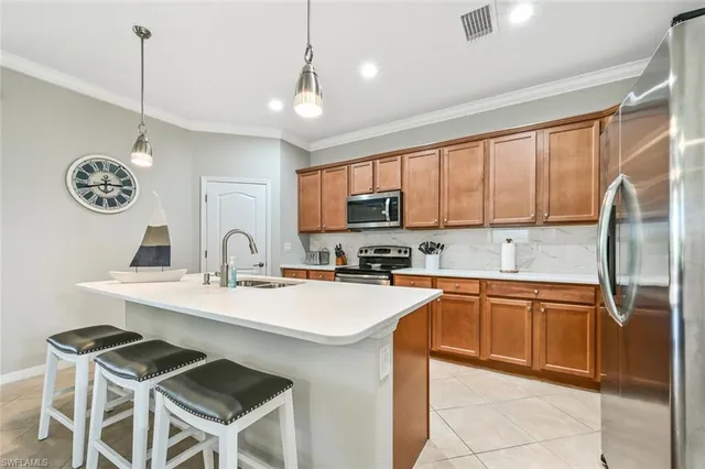 a kitchen with stainless steel appliances granite countertop a stove refrigerator a sink and dishwasher with wooden floor