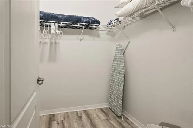 a view of walk in closet with clothes and shoes