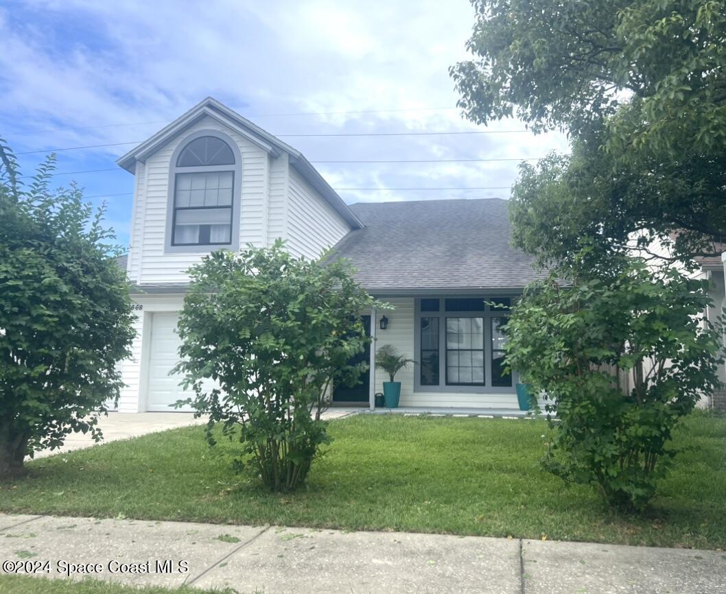 1668 Clover Circle Melbourne, FL 32935 - Photo 1 of 16 a front view of a house with a garden