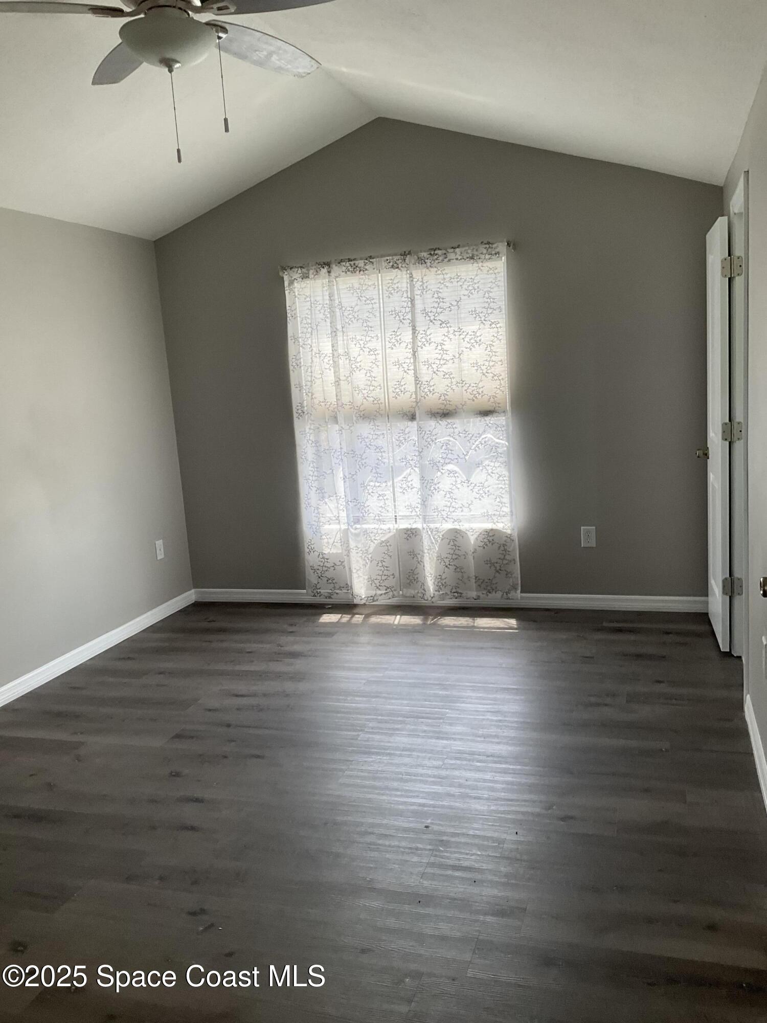 1668 Clover Circle Melbourne, FL 32935 - Photo 11 of 16 an empty room with wooden floor and windows