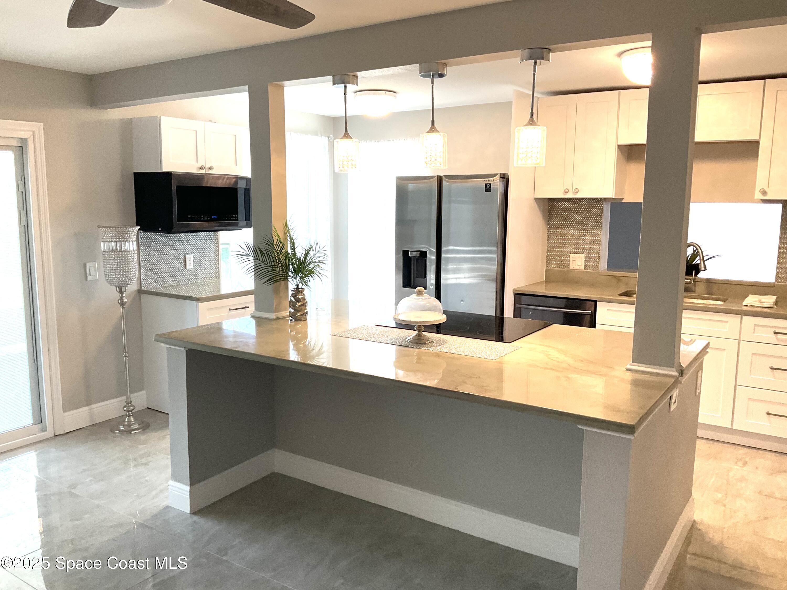 1668 Clover Circle Melbourne, FL 32935 - Photo 2 of 16 a kitchen with a sink and a large mirror
