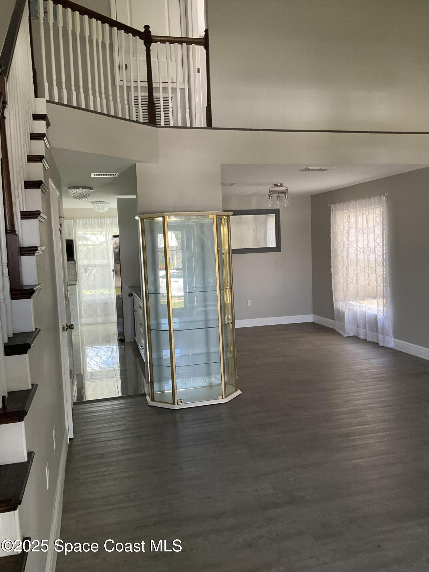 1668 Clover Circle Melbourne, FL 32935 - Photo 4 of 16 a view of a hallway with wooden floor and staircase