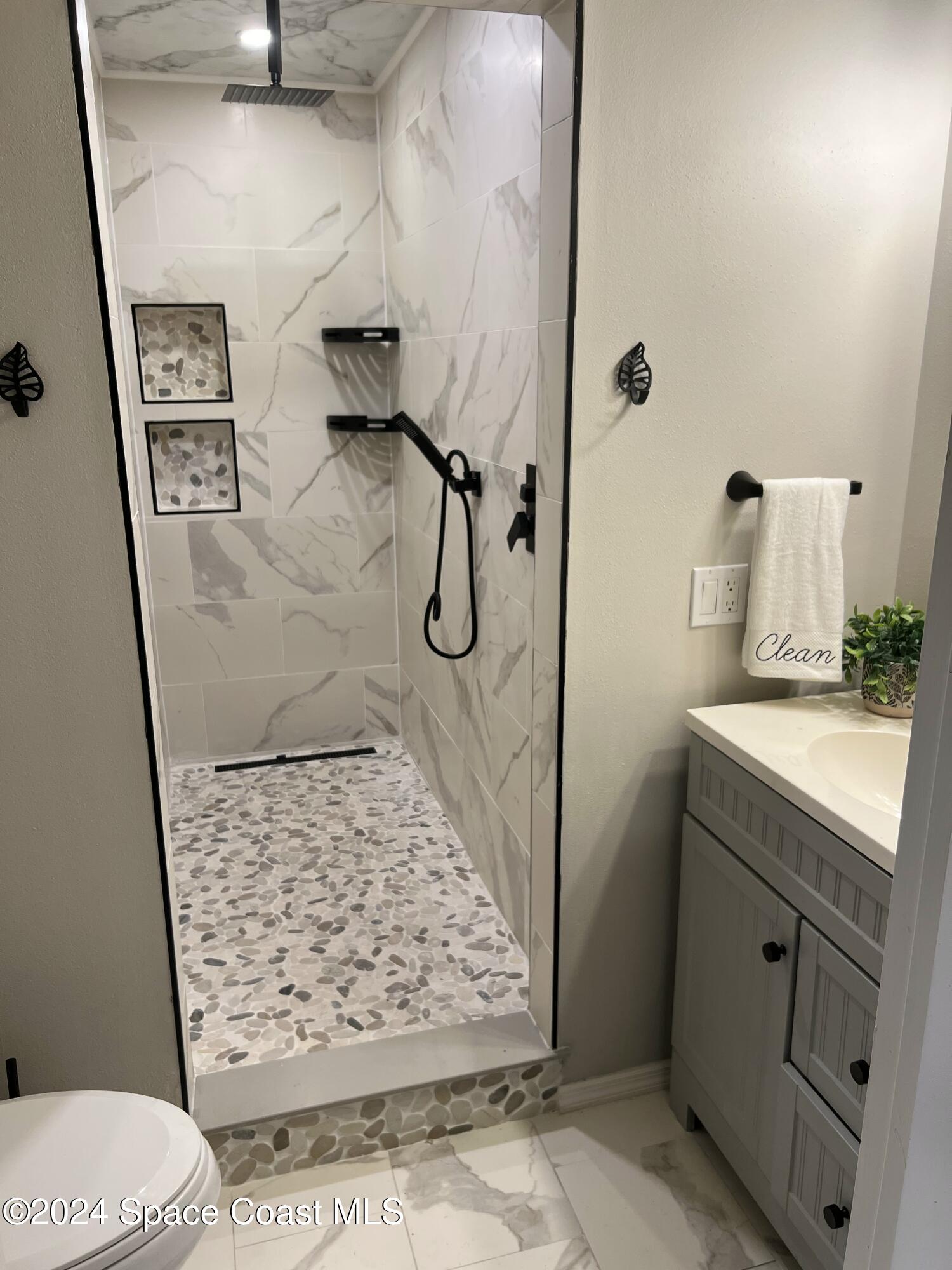 1668 Clover Circle Melbourne, FL 32935 - Photo 7 of 16 a bathroom with a granite countertop sink a toilet and shower