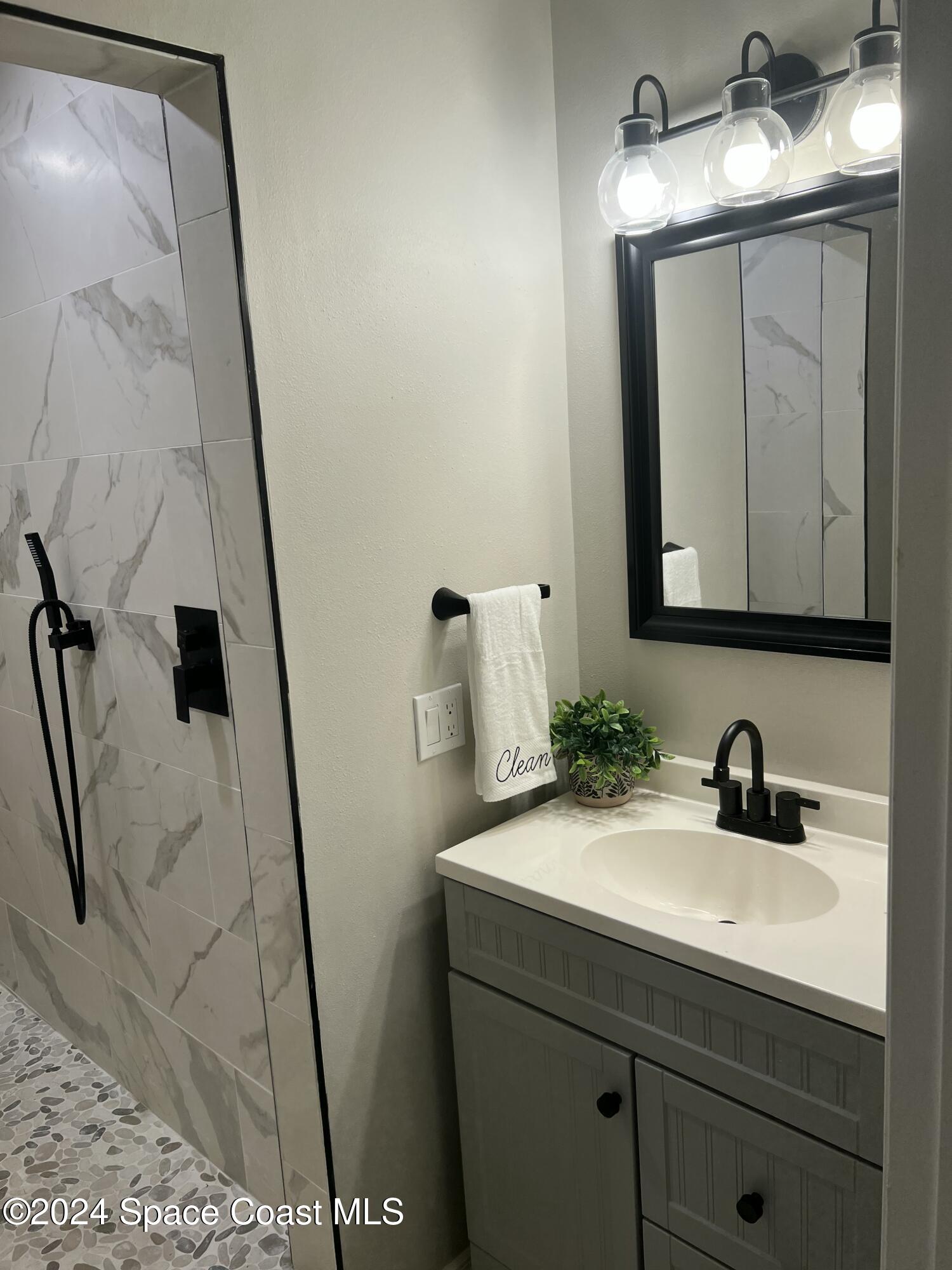1668 Clover Circle Melbourne, FL 32935 - Photo 8 of 16 a bathroom with a sink and mirror with vanity