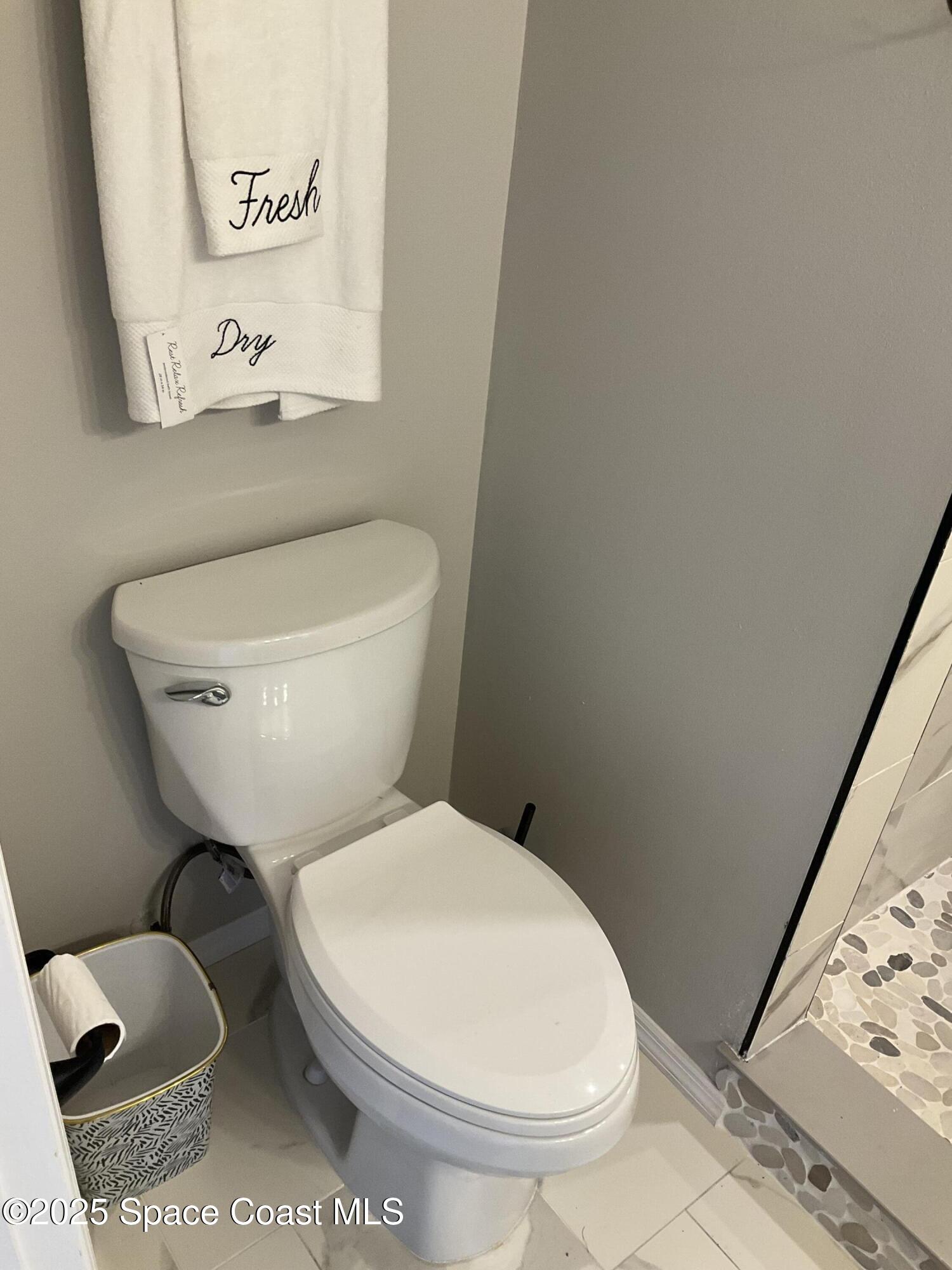 1668 Clover Circle Melbourne, FL 32935 - Photo 9 of 16 a white toilet sitting next to a bathroom sink