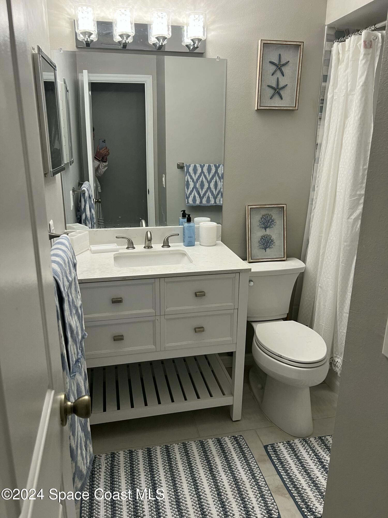 1668 Clover Circle Melbourne, FL 32935 - Photo 10 of 16 a bathroom with a toilet a sink and a mirror
