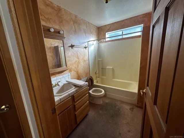 a bathroom with sink shower and toilet