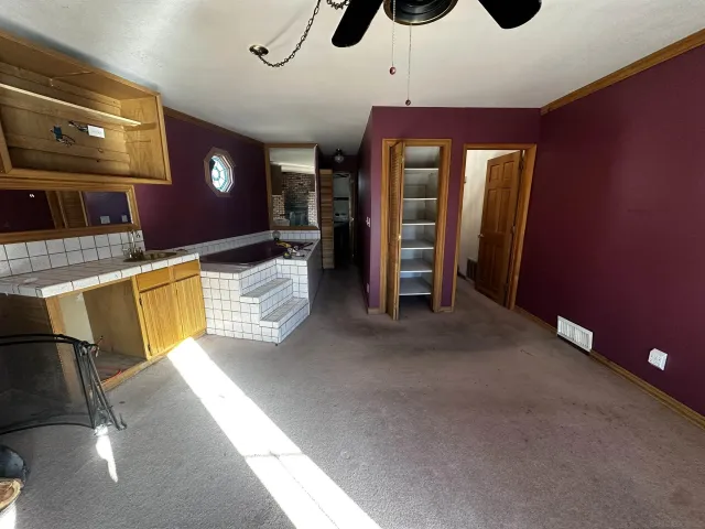 a view of an empty room with window and a fireplace