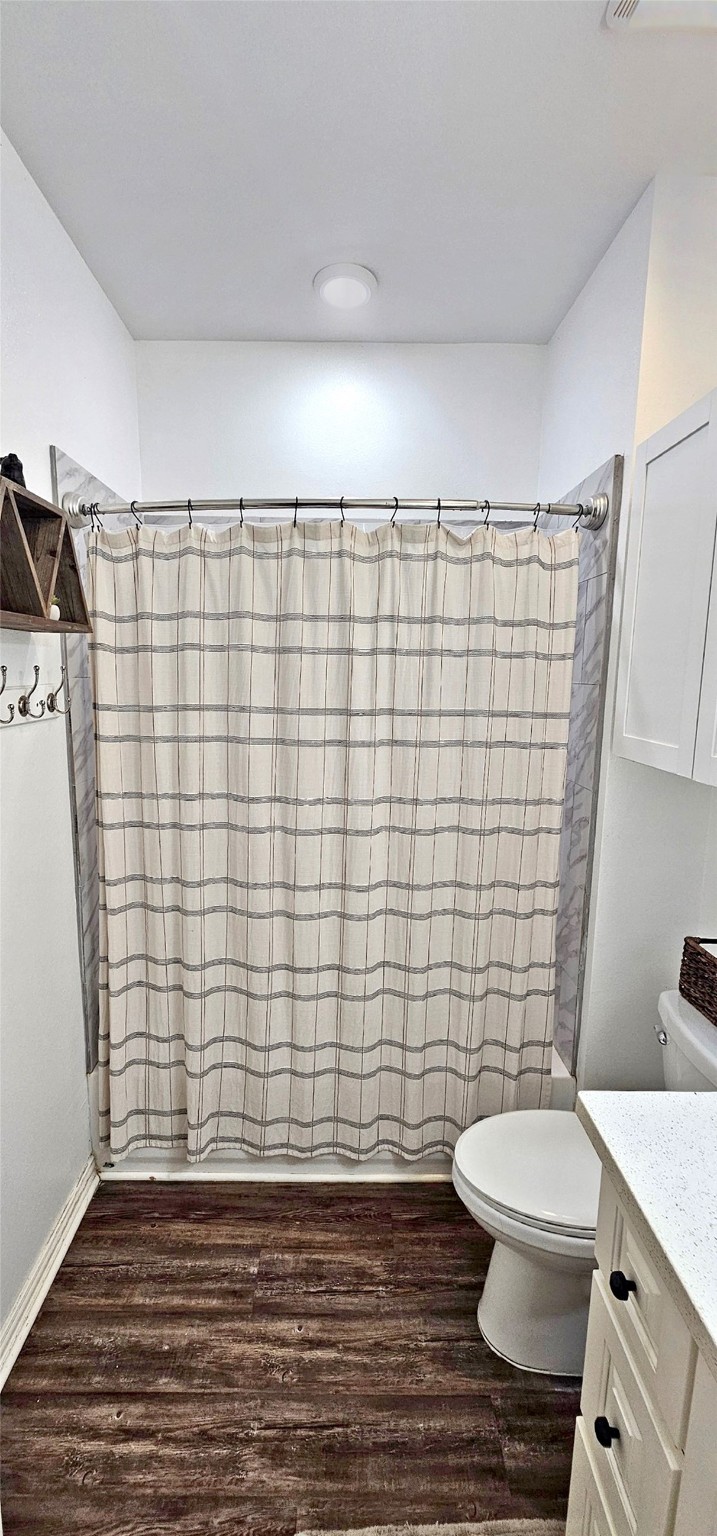 201 Smith Street Columbus, TX 78934 - Photo 14 of 20 a bathroom with a toilet and a shower curtain