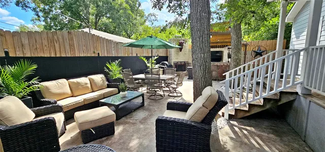 a view of a patio with couches chairs and a table and chairs with wooden fence