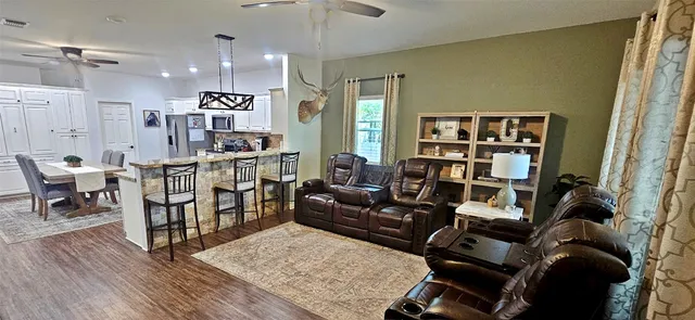 a living room with furniture a rug and a bookshelf