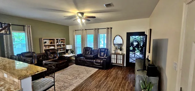 a living room with furniture and wooden floor